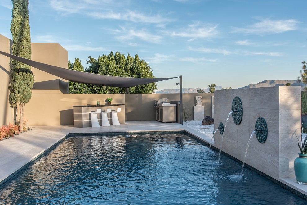 Diseño de piscina con fuente alargada contemporánea grande rectangular en patio trasero con entablado