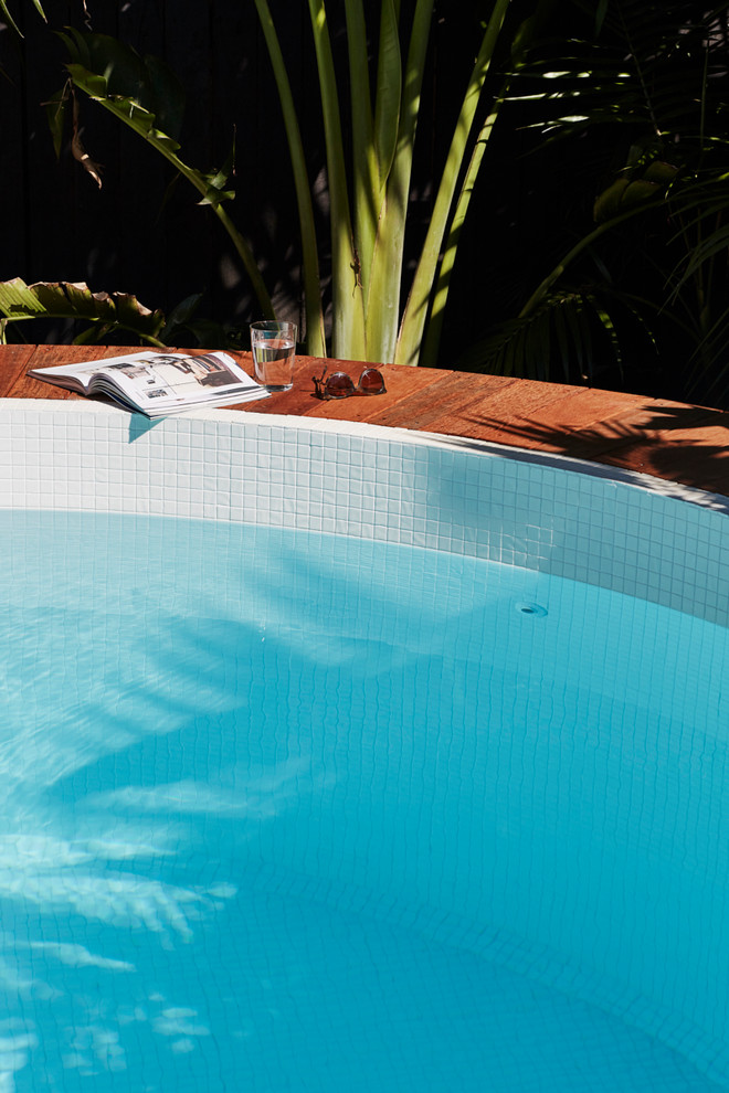 Cette image montre une piscine hors-sol et arrière design de taille moyenne et ronde avec des pavés en pierre naturelle.