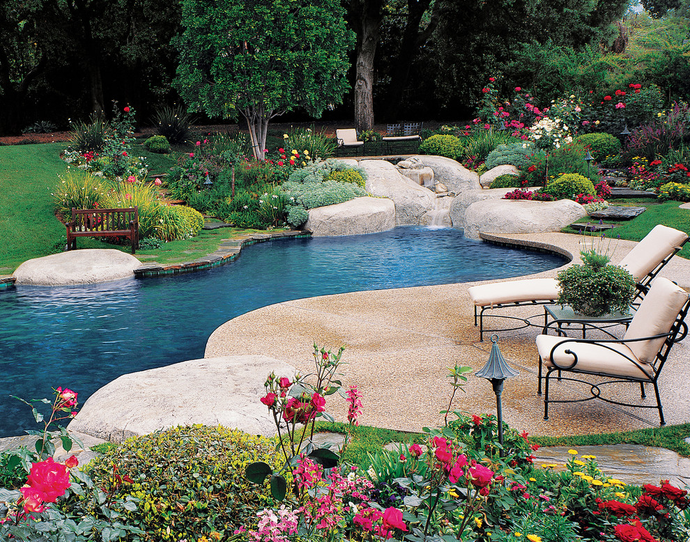 На фото: бассейн произвольной формы на заднем дворе в современном стиле с покрытием из бетонных плит и фонтаном с