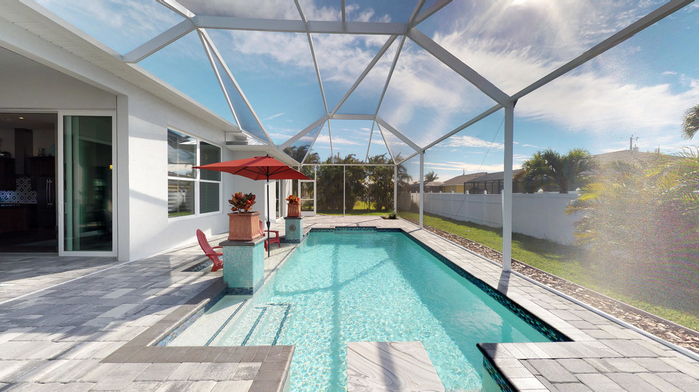 Ispirazione per una grande piscina stile marinaro personalizzata dietro casa con una dépendance a bordo piscina e pavimentazioni in cemento