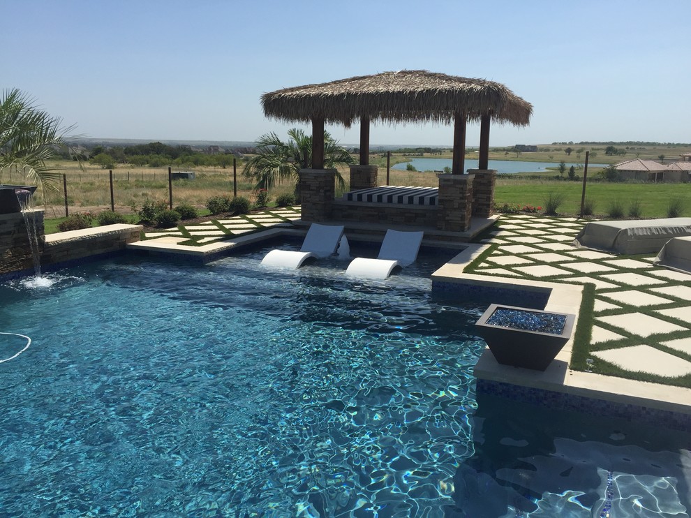 Foto de piscinas y jacuzzis alargados de estilo americano extra grandes rectangulares en patio trasero con adoquines de hormigón