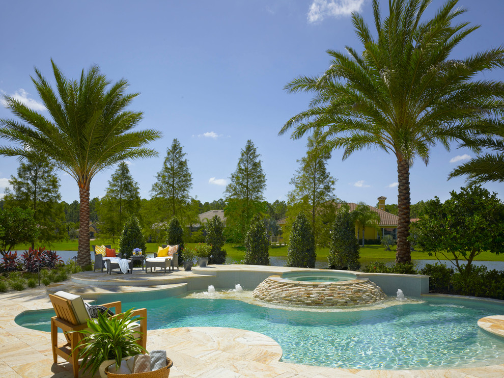 Esempio di una grande piscina tropicale personalizzata dietro casa con una vasca idromassaggio e piastrelle