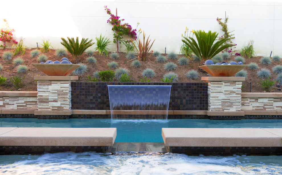 Foto de piscinas y jacuzzis mediterráneos rectangulares en patio trasero con losas de hormigón
