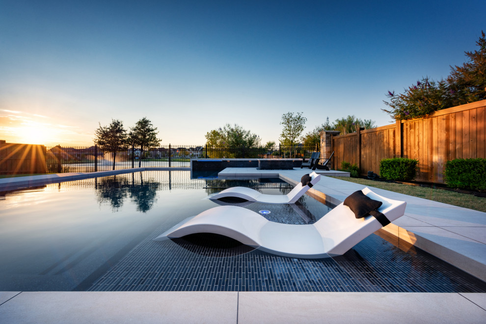 Photo of a medium sized modern back custom shaped swimming pool in Dallas with a water feature.