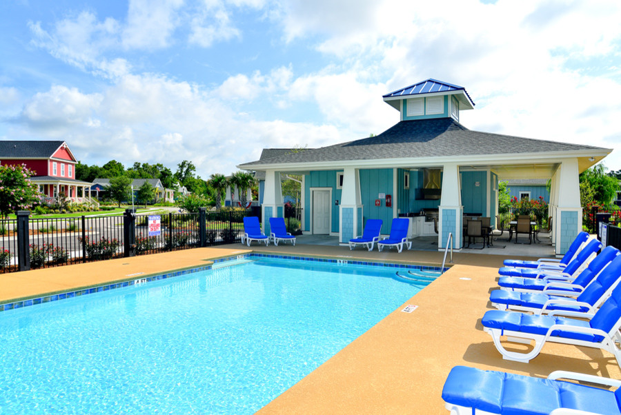 Immagine di una piscina monocorsia stile marinaro rettangolare di medie dimensioni e davanti casa con una dépendance a bordo piscina e cemento stampato