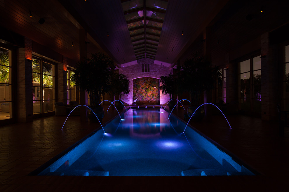 Großer Klassischer Indoor-Pool in rechteckiger Form mit Wasserspiel und Pflastersteinen in Austin