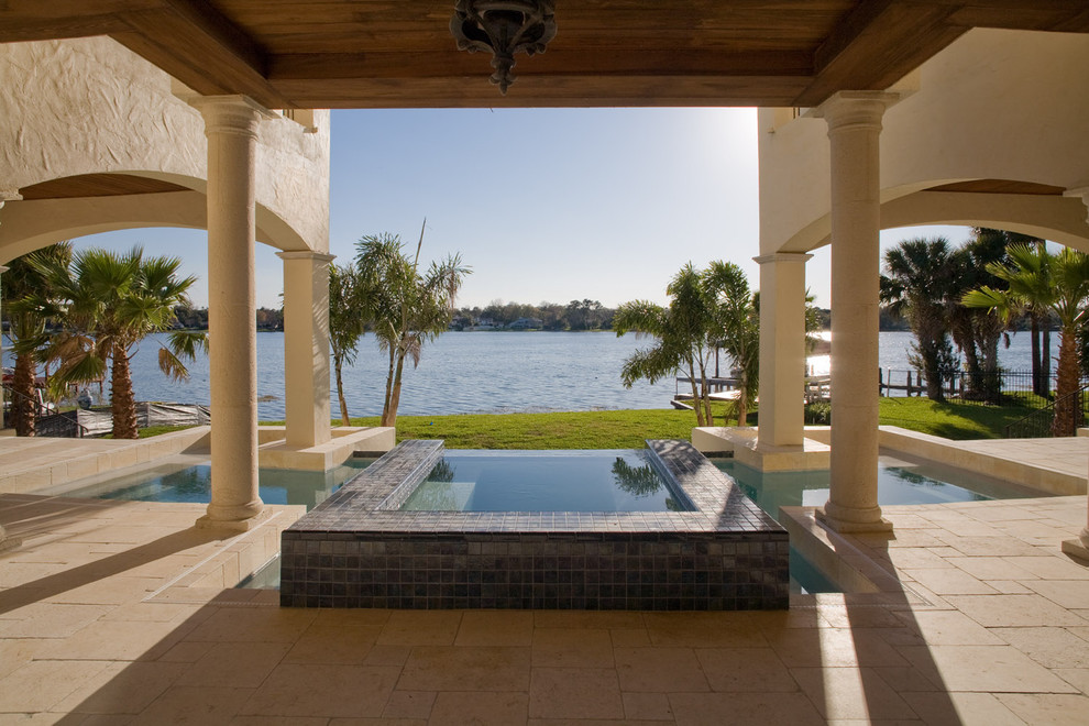 Idée de décoration pour une piscine méditerranéenne sur mesure avec des pavés en pierre naturelle.