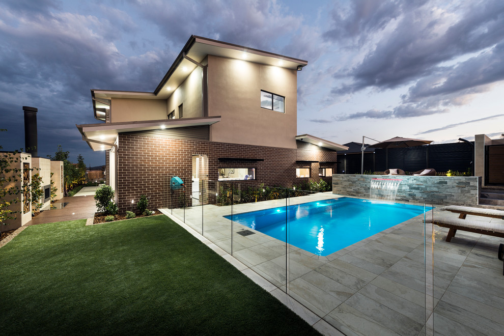 Стильный дизайн: спортивный, прямоугольный бассейн среднего размера на заднем дворе в современном стиле с фонтаном и покрытием из плитки - последний тренд