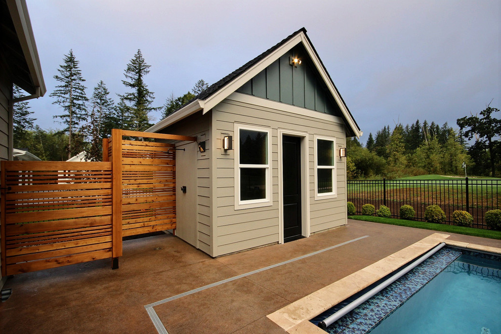 Foto de casa de la piscina y piscina alargada clásica renovada grande rectangular en patio trasero con losas de hormigón