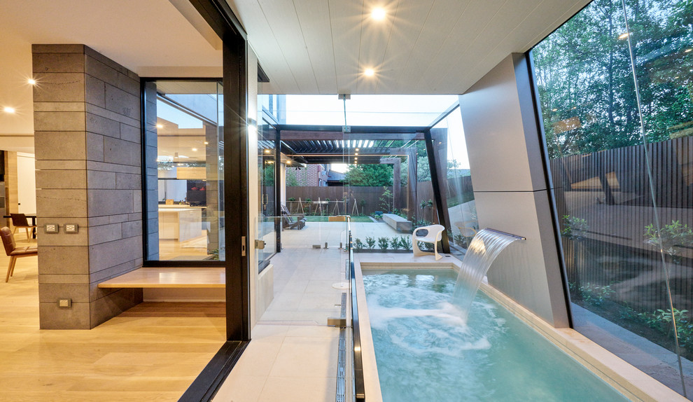 Ejemplo de piscina con fuente alargada contemporánea interior y rectangular con suelo de baldosas
