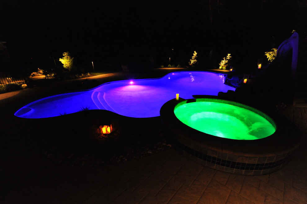Foto di una grande piscina chic personalizzata dietro casa con una vasca idromassaggio e pavimentazioni in cemento