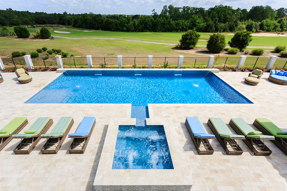Идея дизайна: огромный спортивный, прямоугольный бассейн на заднем дворе в стиле неоклассика (современная классика) с джакузи и покрытием из каменной брусчатки