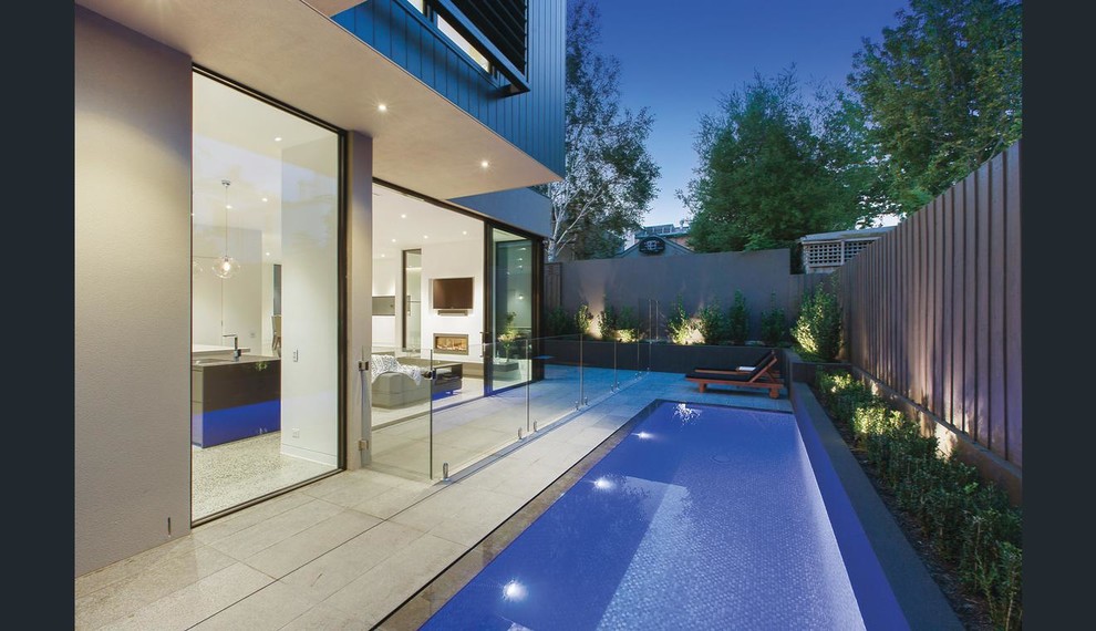 Photo of a medium sized modern back rectangular lengths swimming pool in Melbourne with natural stone paving.