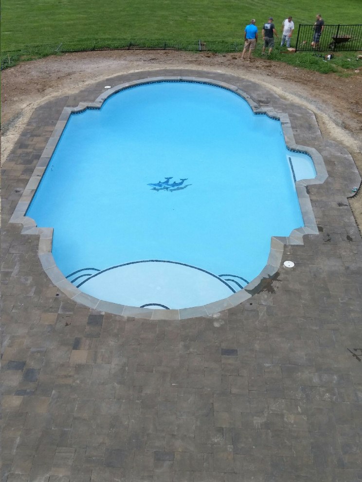На фото: большой спортивный, прямоугольный бассейн на заднем дворе в классическом стиле с покрытием из каменной брусчатки с
