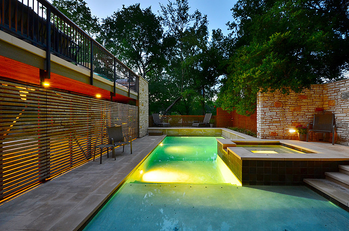 Medium sized modern back rectangular lengths hot tub in Austin with concrete slabs.
