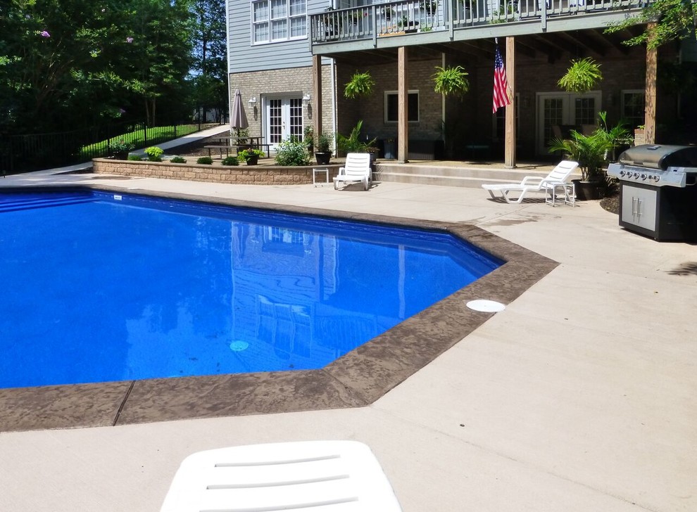 Photo of a large traditional back swimming pool in Richmond with stamped concrete.