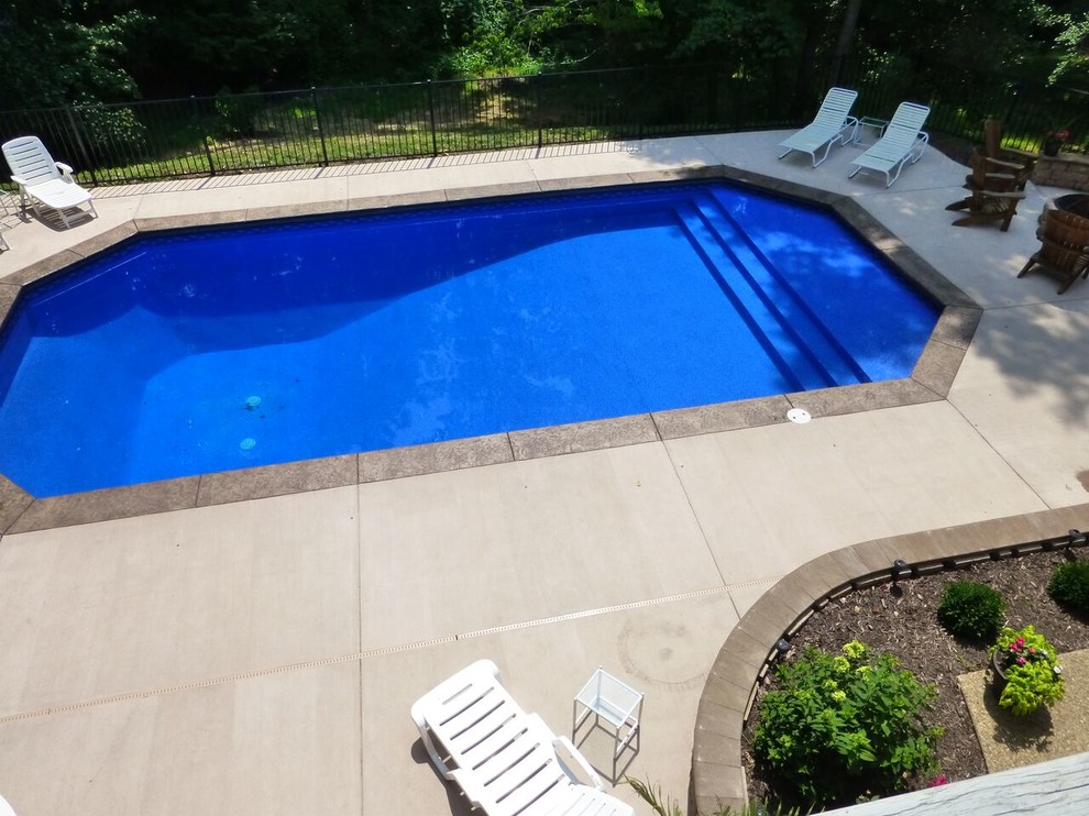 Пример оригинального дизайна: большой бассейн на заднем дворе в классическом стиле с покрытием из декоративного бетона