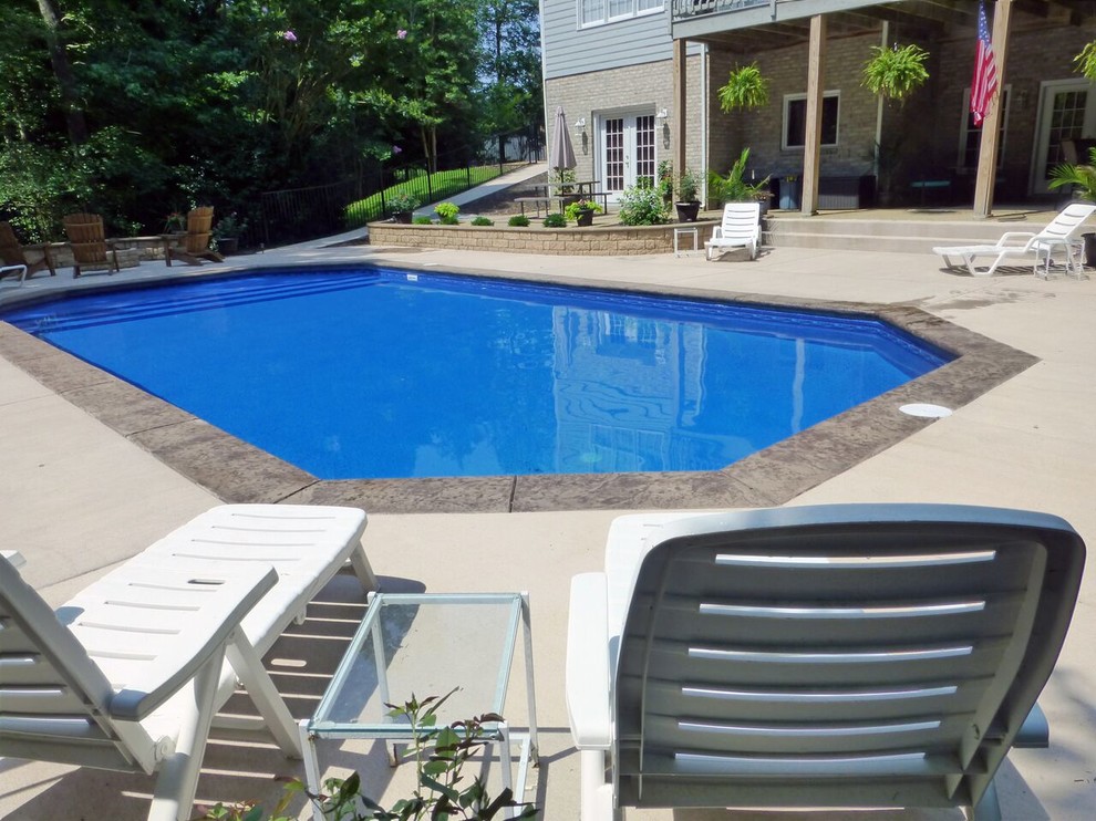 Large classic back swimming pool in Richmond with stamped concrete.