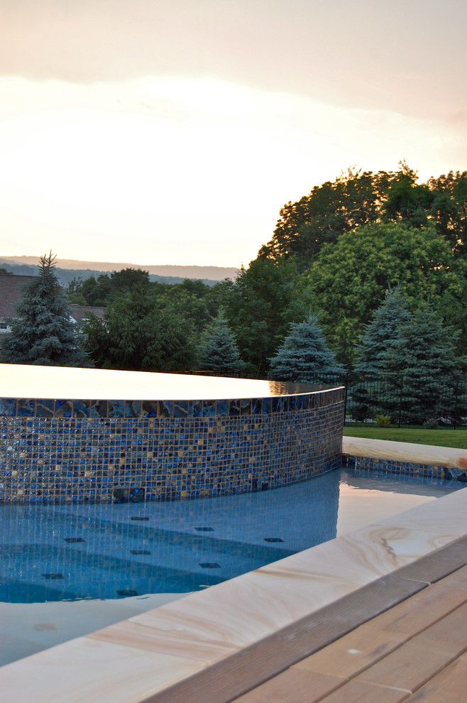 Cette image montre une piscine arrière bohème de taille moyenne et sur mesure avec une terrasse en bois.