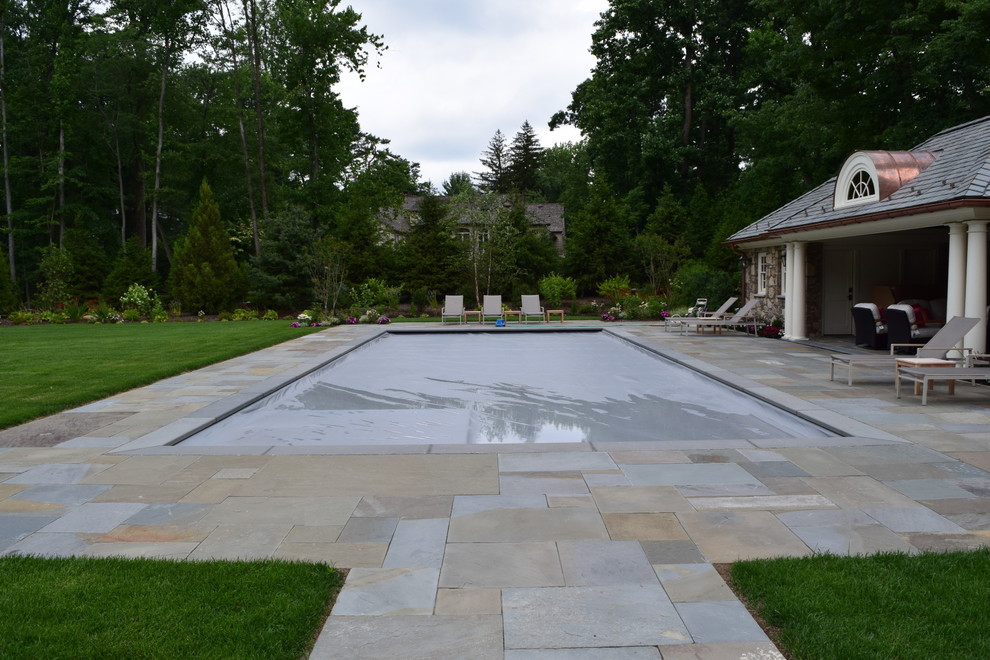 Foto di una grande piscina tradizionale rettangolare dietro casa con una dépendance a bordo piscina e pavimentazioni in pietra naturale