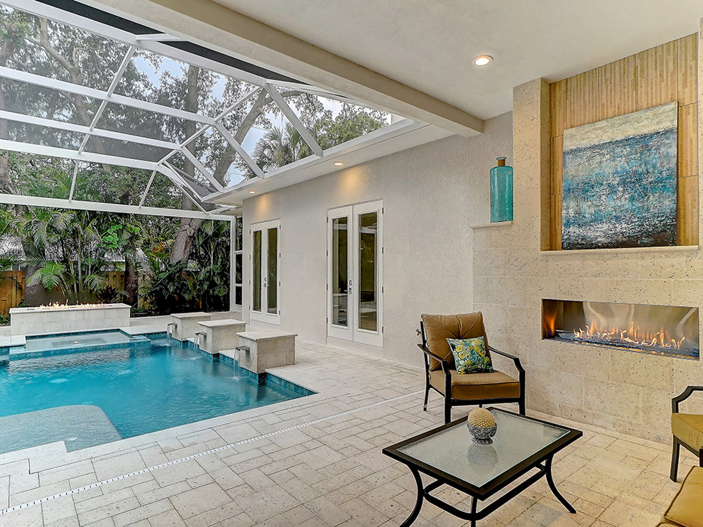 Imagen de piscina con fuente clásica renovada de tamaño medio rectangular en patio trasero con adoquines de hormigón