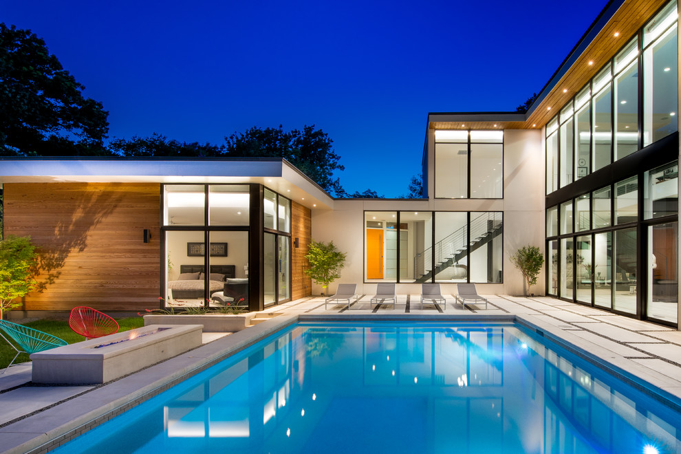 Стильный дизайн: большой прямоугольный бассейн на заднем дворе в современном стиле с покрытием из бетонных плит - последний тренд