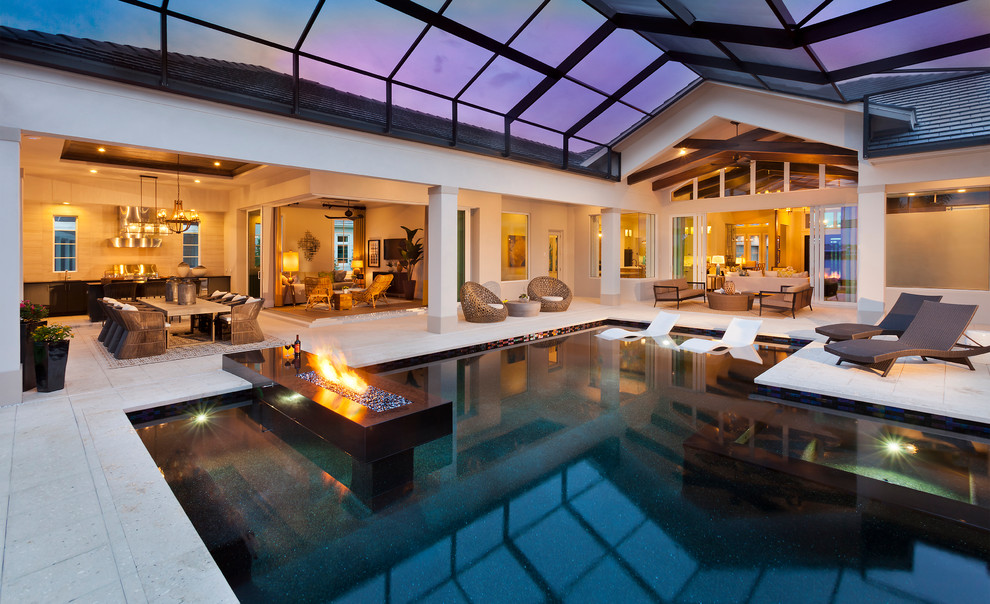 Foto di un'ampia piscina a sfioro infinito tradizionale personalizzata dietro casa con pavimentazioni in pietra naturale