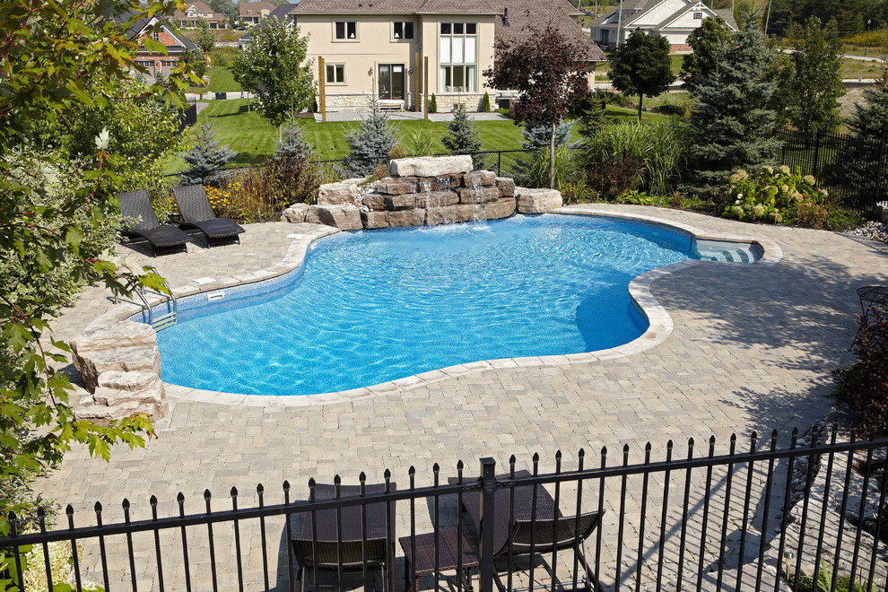 Ejemplo de piscina con fuente natural contemporánea grande a medida en patio trasero con adoquines de ladrillo