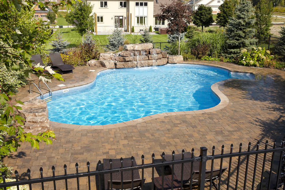 Foto de piscina con fuente natural contemporánea grande a medida en patio trasero con adoquines de ladrillo