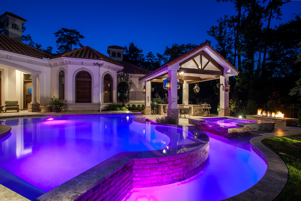 Modelo de casa de la piscina y piscina actual grande a medida en patio trasero con adoquines de piedra natural