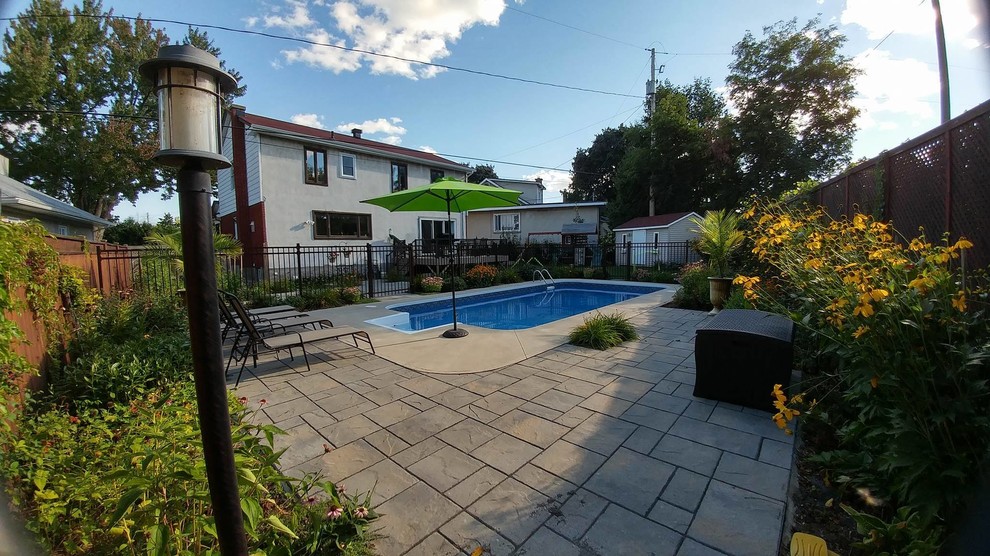 Esempio di una piscina chic rettangolare di medie dimensioni e dietro casa con lastre di cemento