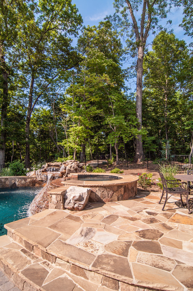 Aménagement d'une piscine classique avec des pavés en pierre naturelle.