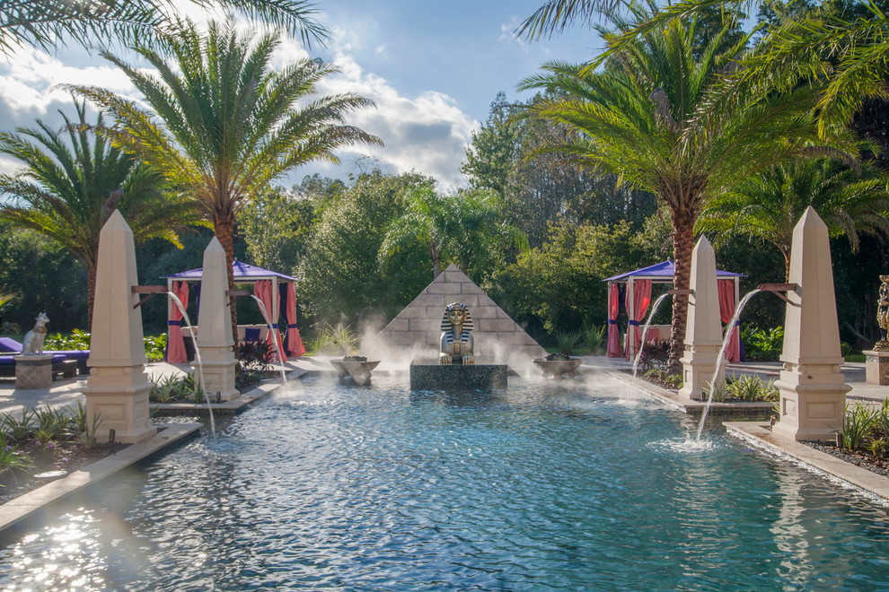 Großer Eklektischer Pool hinter dem Haus in rechteckiger Form mit Wasserspiel und Natursteinplatten in Tampa