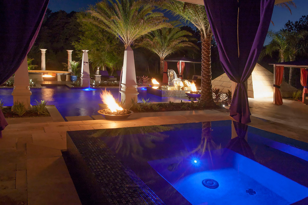 Modelo de piscina con fuente mediterránea grande a medida en patio trasero con adoquines de piedra natural