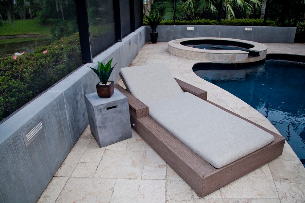 Cette photo montre une piscine arrière moderne de taille moyenne et sur mesure avec des pavés en pierre naturelle et un bain bouillonnant.