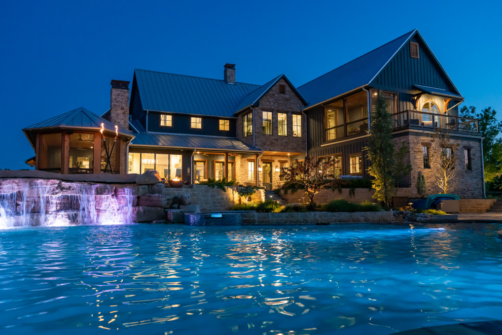 Ispirazione per un'ampia piscina naturale country personalizzata dietro casa con fontane e pavimentazioni in pietra naturale