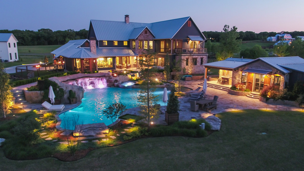 Immagine di un'ampia piscina naturale country personalizzata dietro casa con paesaggistica bordo piscina e pavimentazioni in pietra naturale