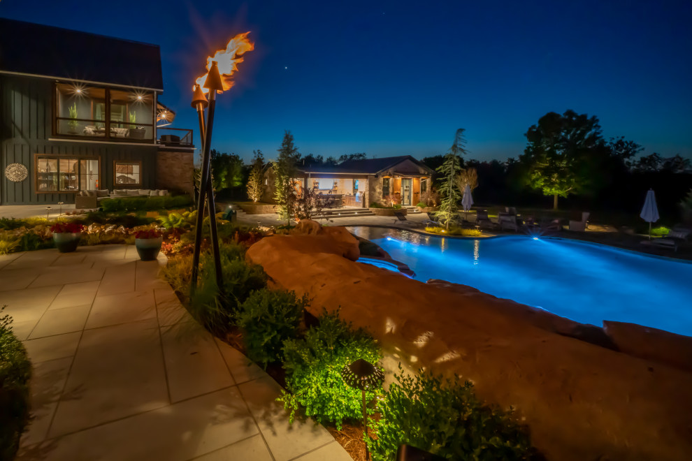 Imagen de piscina natural de estilo de casa de campo extra grande a medida en patio trasero con privacidad y adoquines de piedra natural