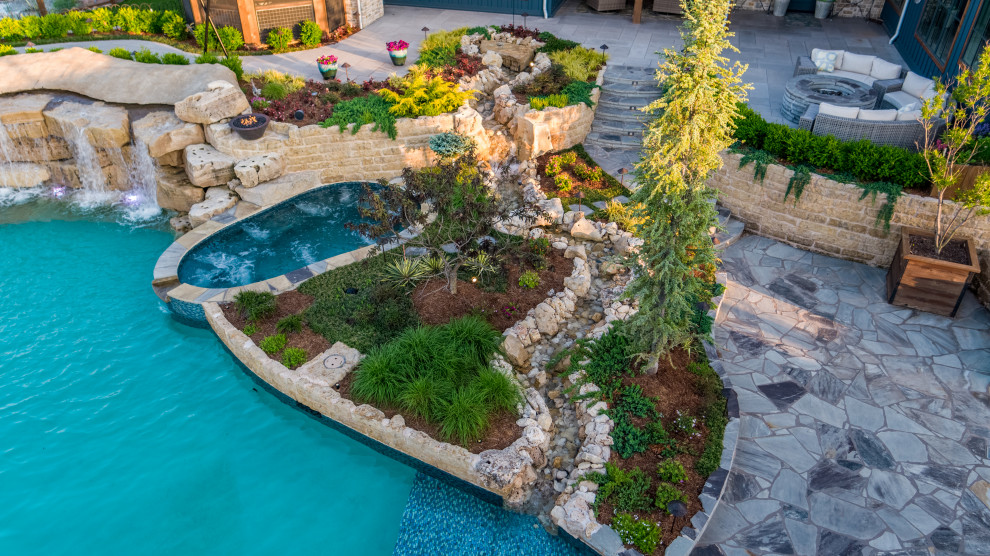 Ejemplo de piscinas y jacuzzis naturales campestres extra grandes a medida en patio trasero con adoquines de piedra natural