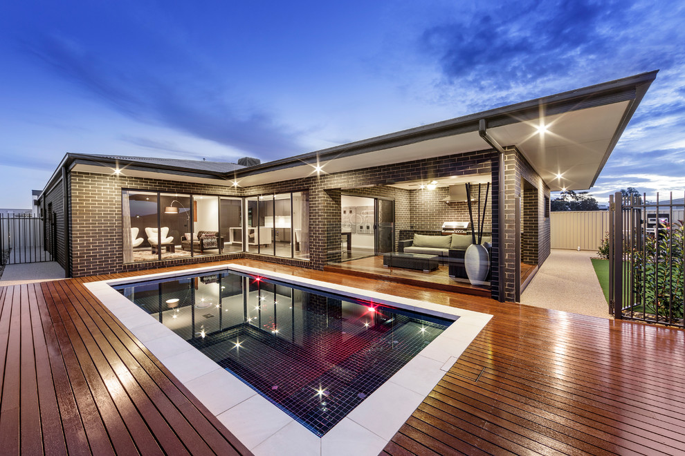 Small modern back rectangular lengths swimming pool in Sydney with decking.