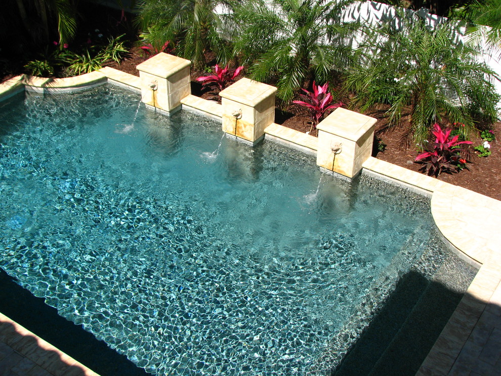 Idee per una piscina mediterranea rettangolare di medie dimensioni e dietro casa con fontane e pavimentazioni in cemento