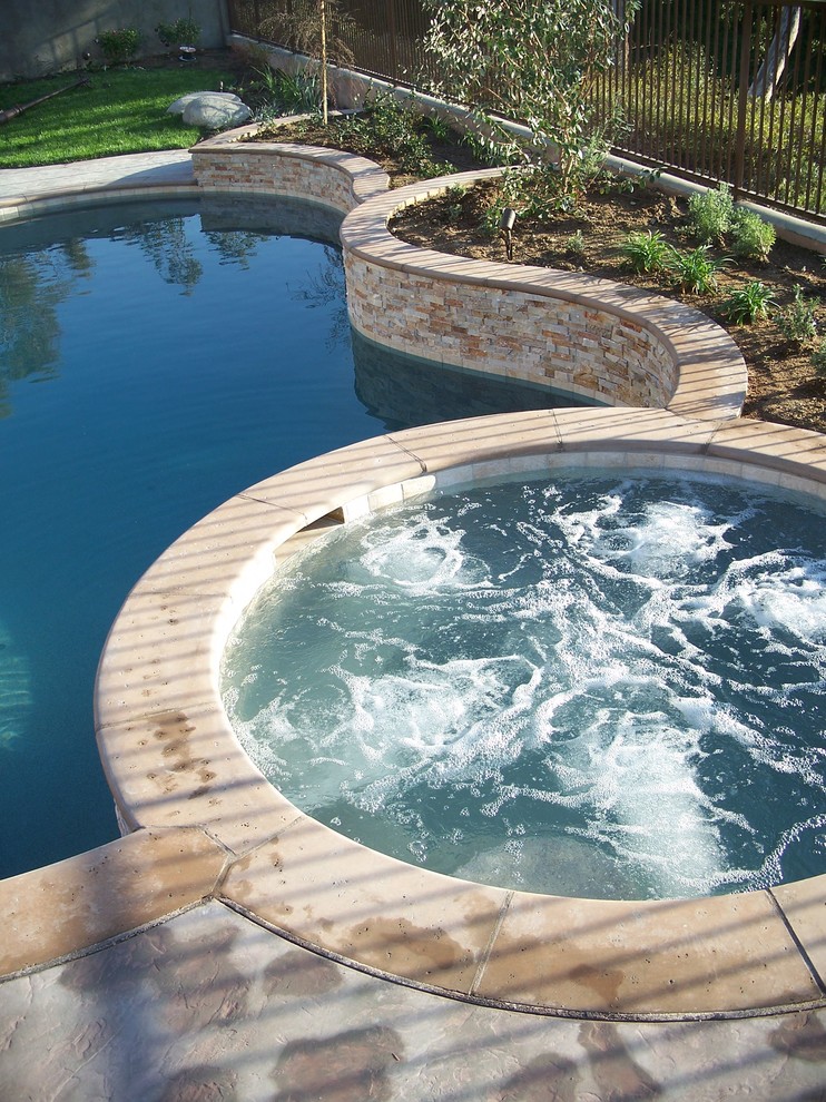 Inspiration for a mid-sized transitional backyard stone and custom-shaped hot tub remodel in Phoenix