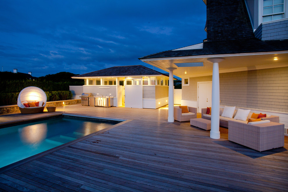 Idées déco pour une très grande piscine arrière contemporaine rectangle avec une terrasse en bois.