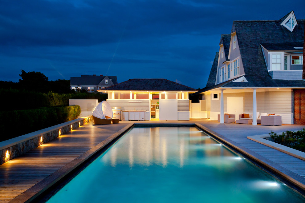 Immagine di un'ampia piscina minimal rettangolare dietro casa con una dépendance a bordo piscina e pedane