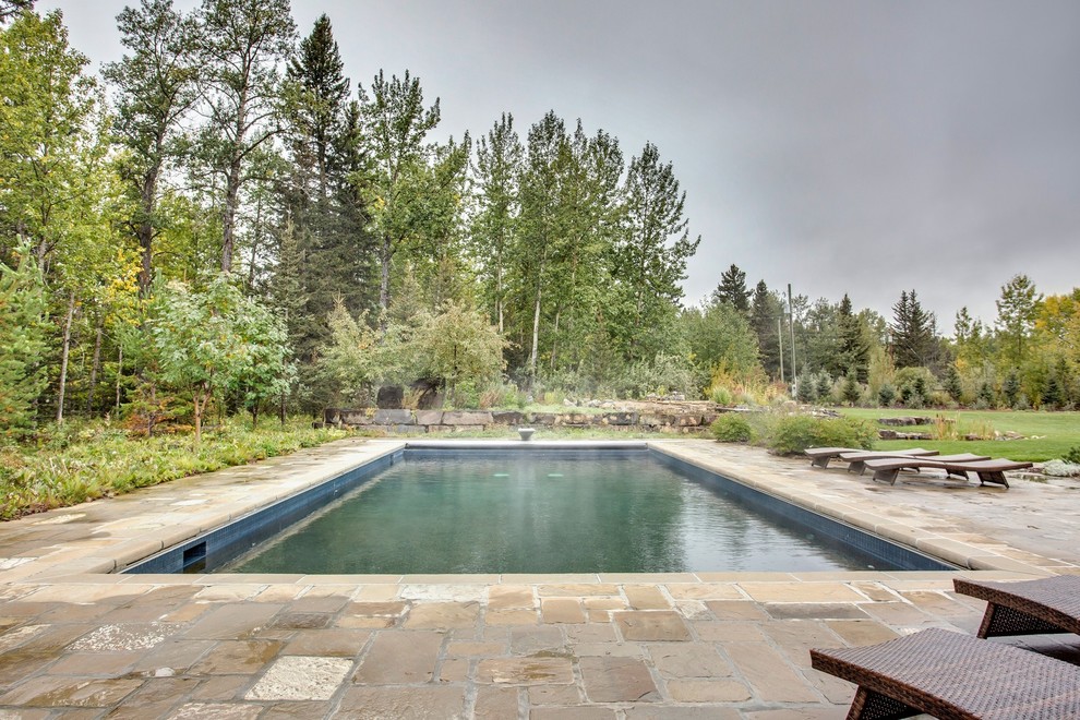 Imagen de piscina elevada rural grande rectangular en patio con adoquines de piedra natural