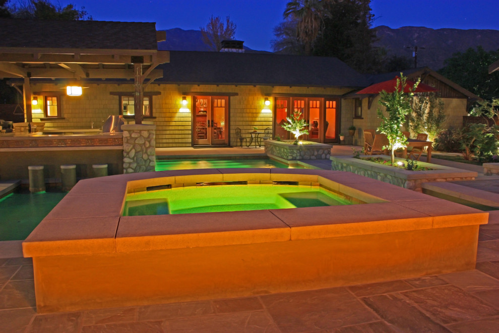 Idee per una grande piscina stile americano personalizzata dietro casa con pavimentazioni in cemento e una vasca idromassaggio