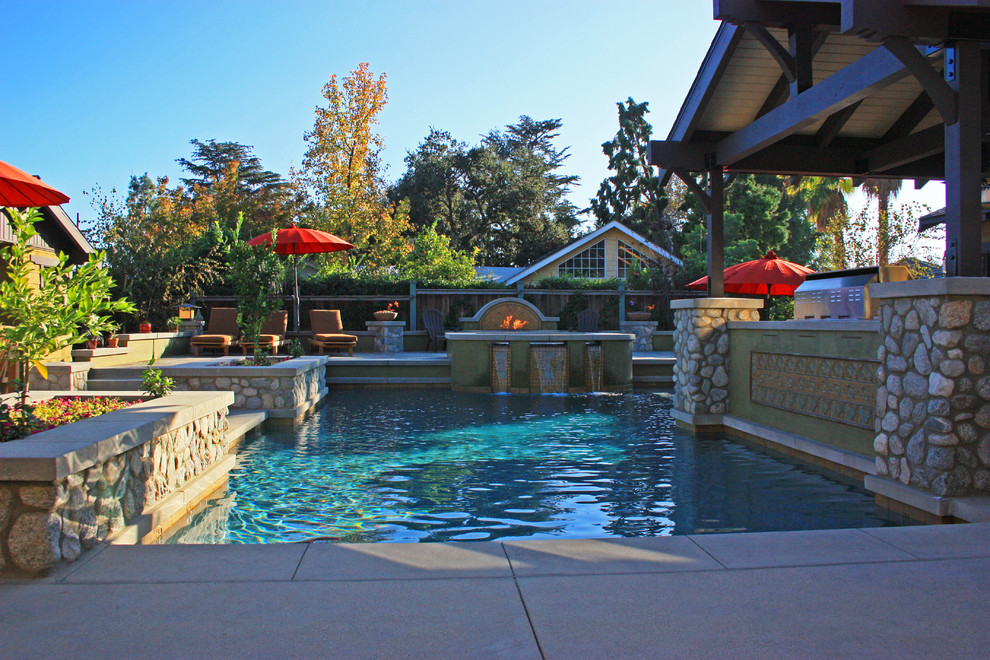 Photo of a large classic back custom shaped hot tub in Los Angeles with concrete paving.