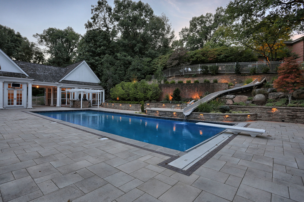 Источник вдохновения для домашнего уюта: прямоугольный бассейн среднего размера на заднем дворе в стиле модернизм с водной горкой и мощением тротуарной плиткой