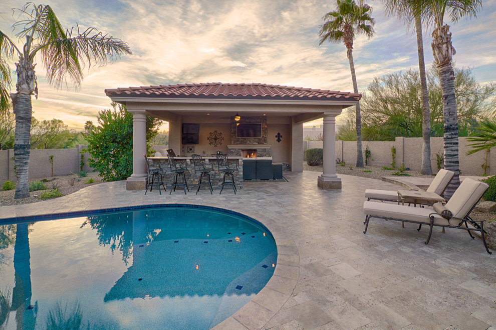 Example of a large tuscan backyard concrete paver natural pool design in Phoenix