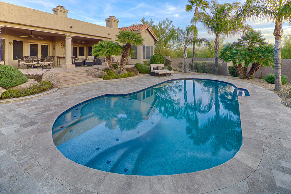 Inspiration for a large mediterranean backyard concrete paver natural pool remodel in Phoenix